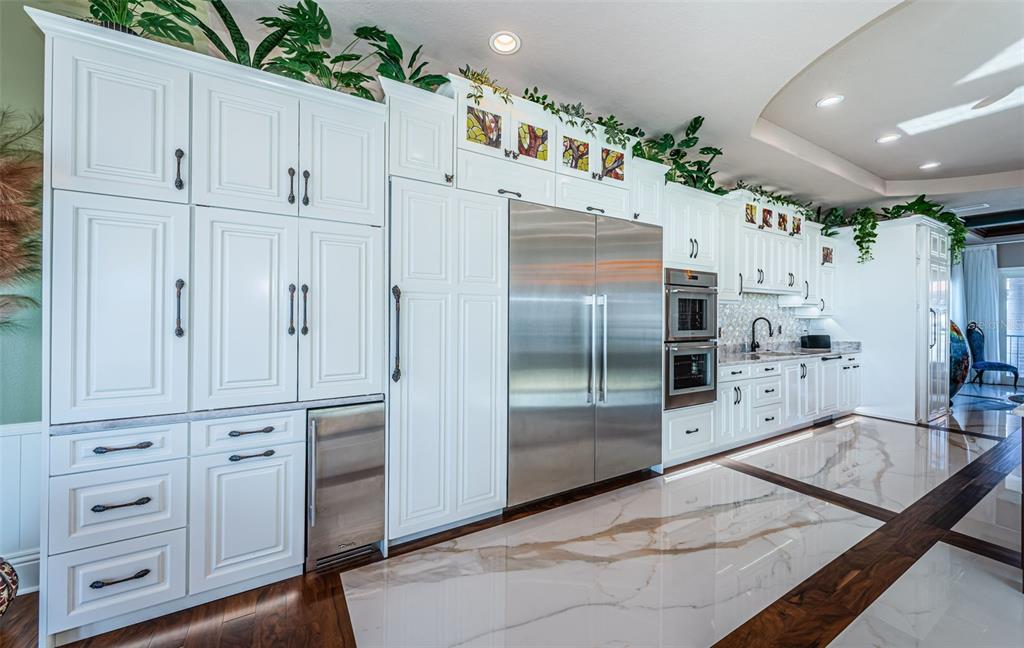 15912 Gulf Boulevard Redington Beach, FL 33708 - Photo 31 of 100 a kitchen with white cabinets and stainless steel appliances