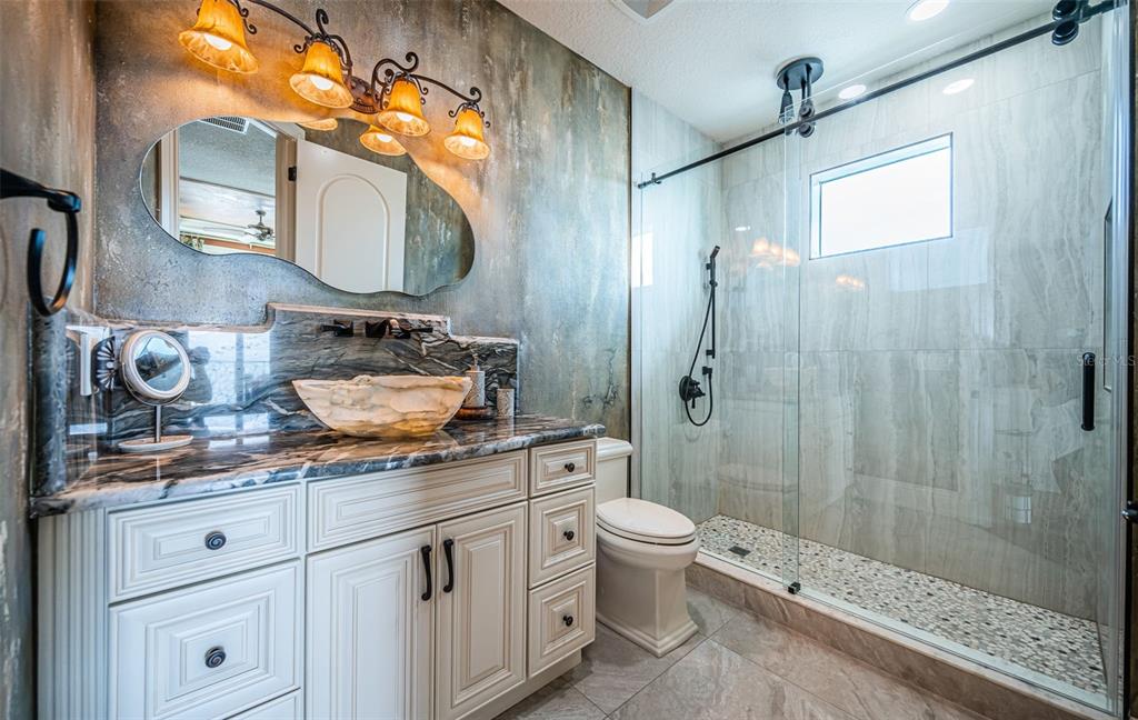 15912 Gulf Boulevard Redington Beach, FL 33708 - Photo 83 of 100 a bathroom with a granite countertop sink a toilet and a mirror