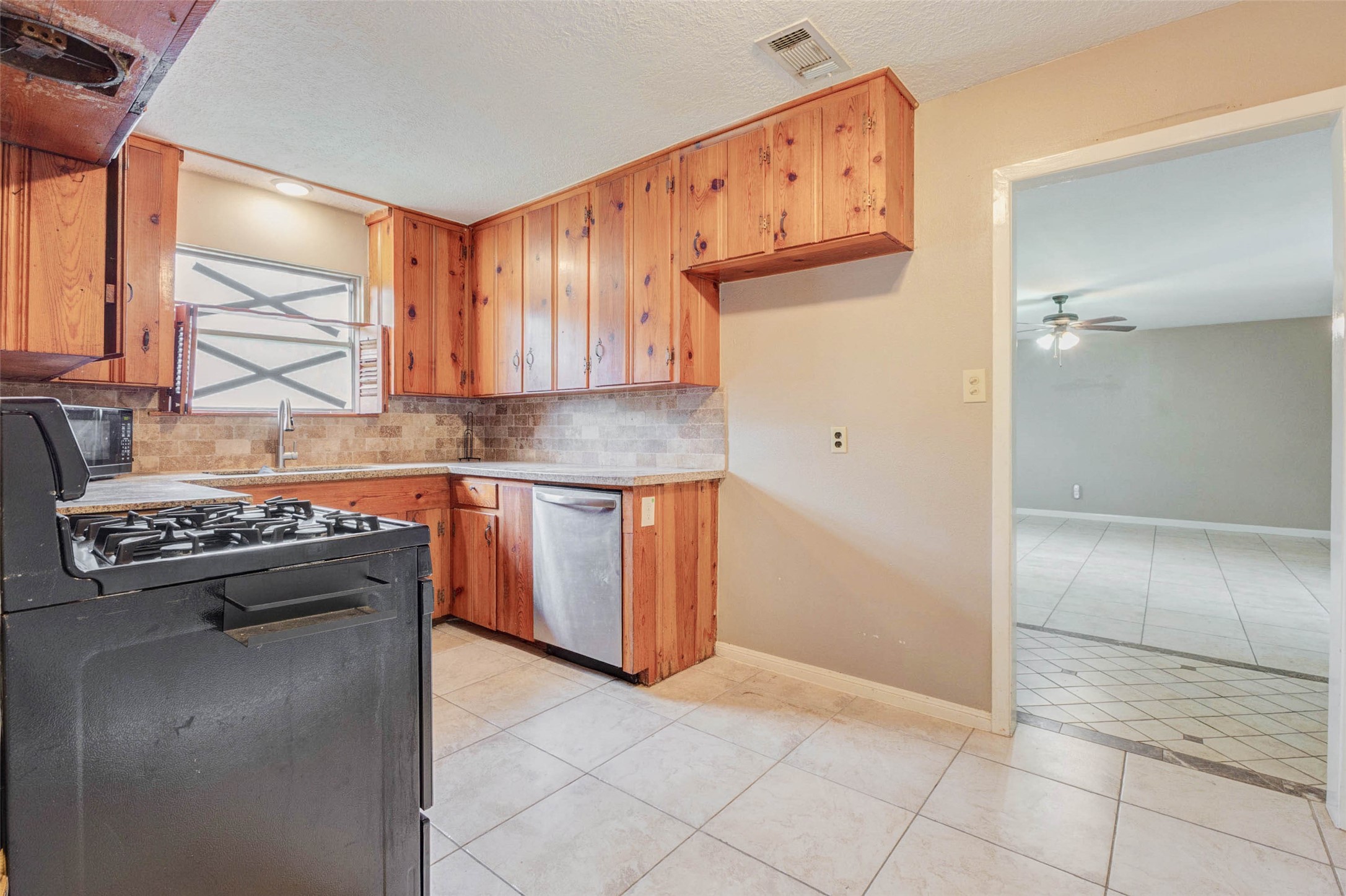 411 Burke Road Pasadena, TX 77506 - Photo 15 of 24 a kitchen with a stove a sink and a refrigerator