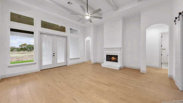 a view of an empty room with a fireplace and a window
