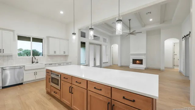 a kitchen with granite countertop a sink stainless steel appliances and white cabinets