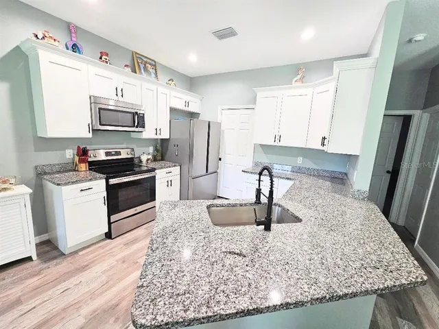 a kitchen with stainless steel appliances granite countertop a sink stove and refrigerator