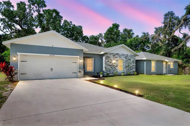a front view of a house with a yard and garage