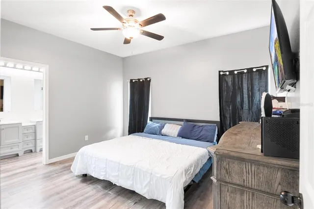 a spacious bedroom with a bed and a flat screen tv