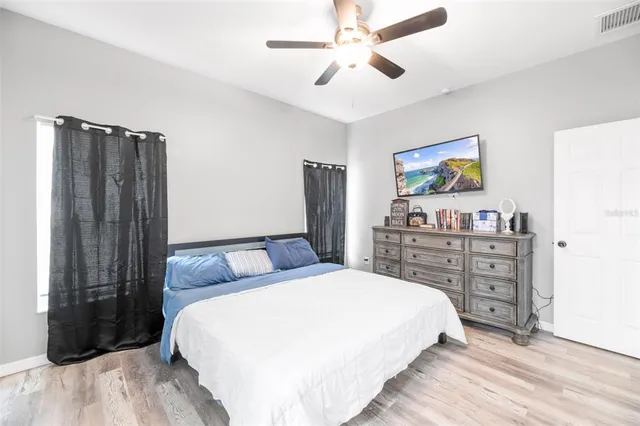 a bedroom with a bed a dresser and a painting on the wall