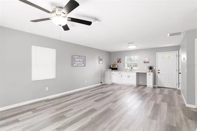 a view of a kitchen with wooden floor and a ceiling fan