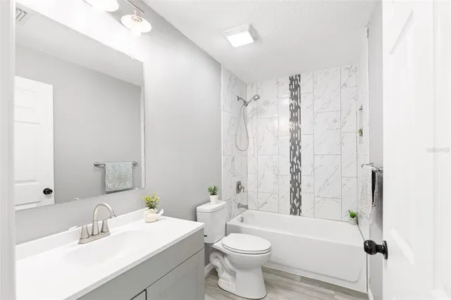 a bathroom with a toilet a sink a mirror a bathtub and shower