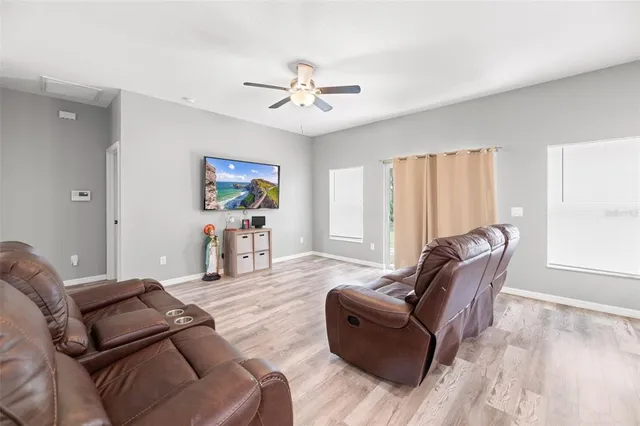 a living room with furniture two window and a chandelier