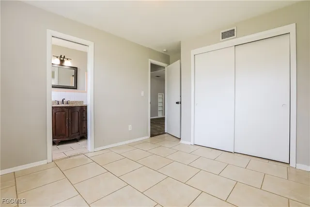a view of an empty room with closet and a window