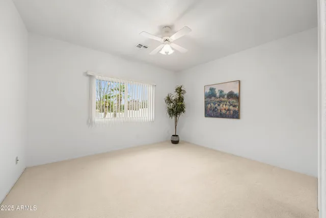 an empty room with a ceiling fan and a window