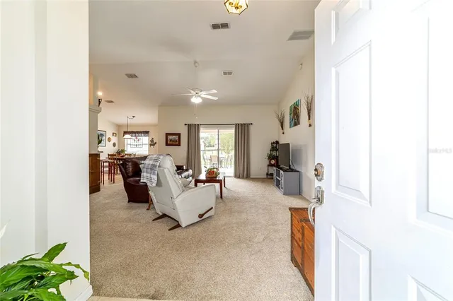 a living room with furniture a flat screen tv and a large window