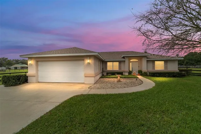 a front view of a house with yard and green space