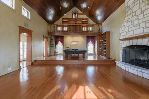 a view of a big room with wooden floor a fireplace and entryway