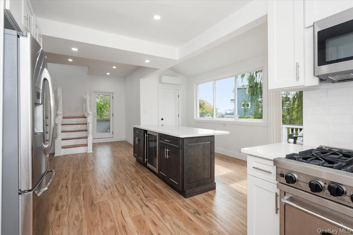 56 Oak Beach Road Babylon, NY 11702 - Photo 14 of 30 Newly remodeled kitchen shines with a oversized center island with quartz countertops and stainless steel appliances.