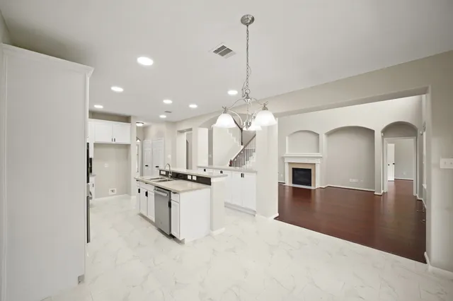 a view of a kitchen with a stove a refrigerator a sink dishwasher with wooden floor and cabinets