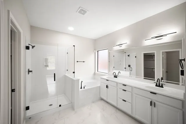 a spacious bathroom with double vanity and mirrors