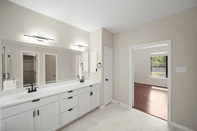a bathroom with a double vanity sink and mirror