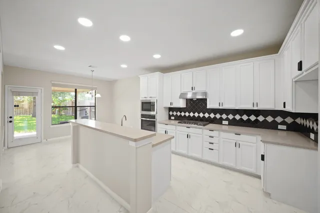 a kitchen with granite countertop a sink and cabinets