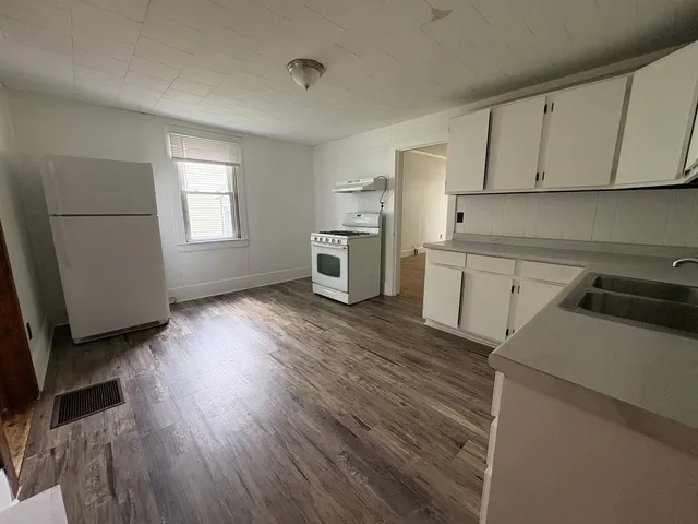 a view of a kitchen with wooden floor and electronic appliances