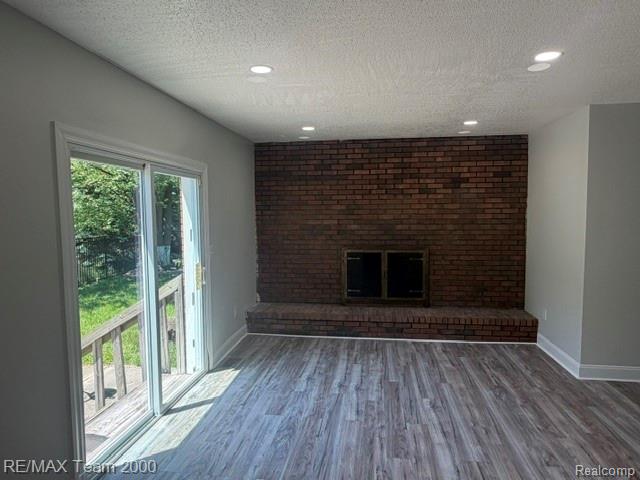 580 Palmerston Street River Rouge, MI 48218 - Photo 6 of 19 Spacious room featuring a brick fireplace with a raised hearth, light wood-finish flooring, and recessed ceiling lighting