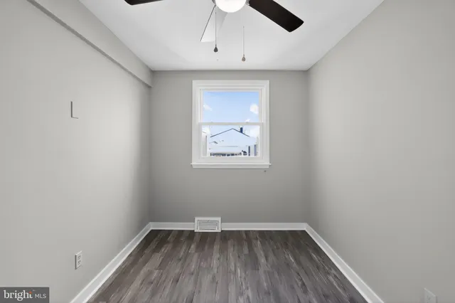an empty room with a window and wooden floor