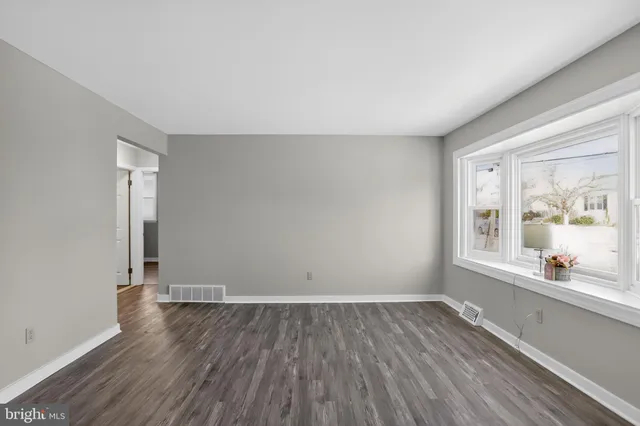 wooden floor in an empty room with a window