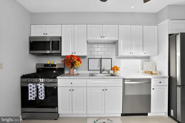 a kitchen with white cabinets and appliances