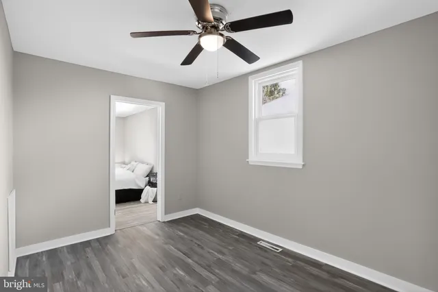 a view of empty room with wooden floor