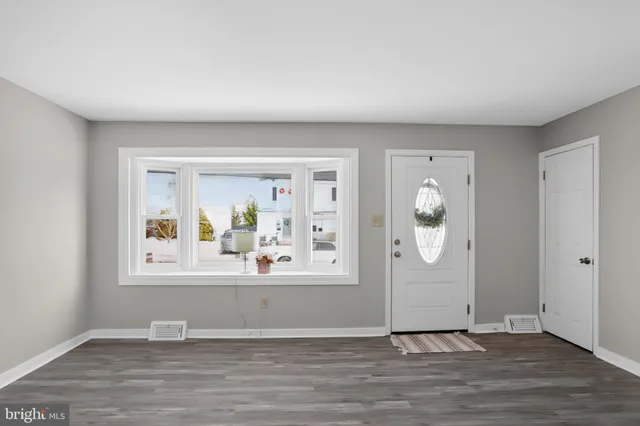 an empty room with wooden floor and mirror