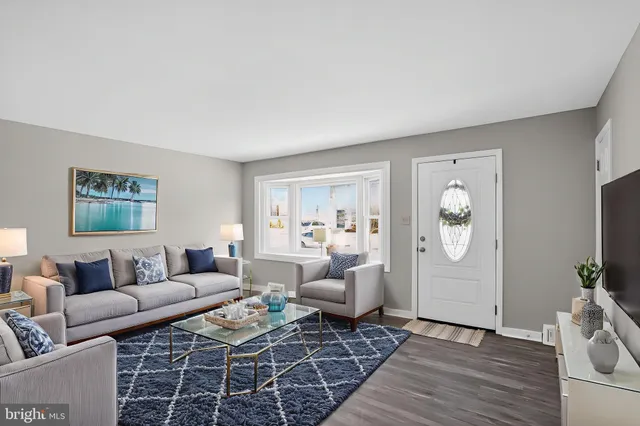 a living room with furniture a flat screen tv and a window