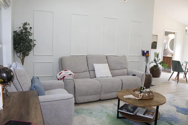 a living room with furniture a chandelier and a dining table