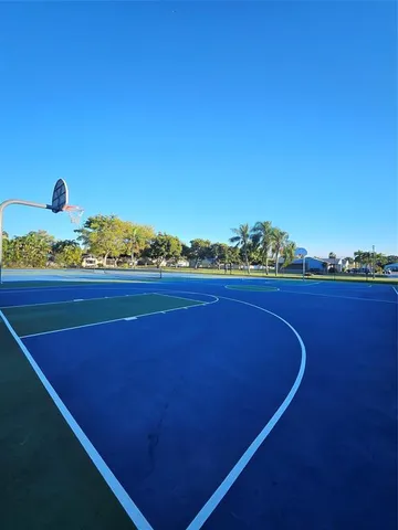 a view of a patio with table and chairs under an umbrella with a small yard