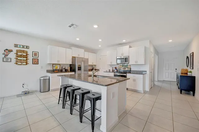 a view of a dining room with furniture and a kitchen