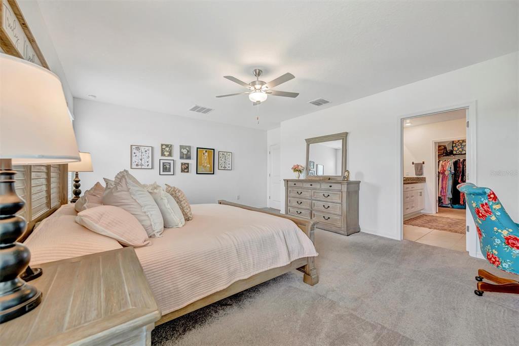 11112 Linden Depot Road San Antonio, FL 33576 - Photo 39 of 82 a bedroom with a bed and a chandelier