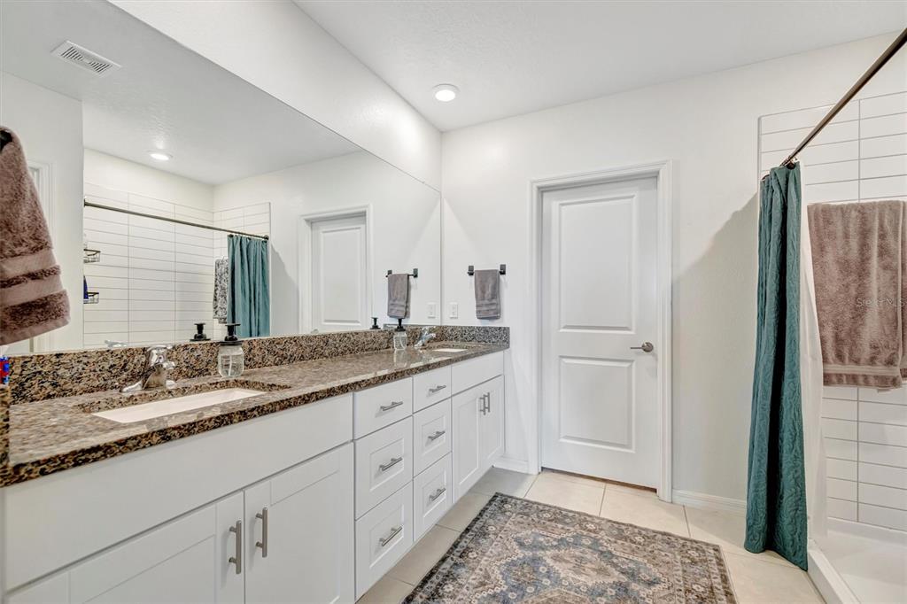 11112 Linden Depot Road San Antonio, FL 33576 - Photo 42 of 82 a spacious bathroom with a granite countertop sink and a mirror