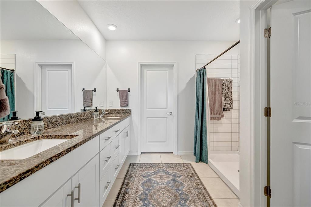 11112 Linden Depot Road San Antonio, FL 33576 - Photo 43 of 82 a spacious bathroom with a granite countertop sink and a mirror
