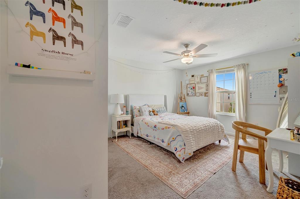 11112 Linden Depot Road San Antonio, FL 33576 - Photo 50 of 82 a spacious bedroom with a bed and a chandelier