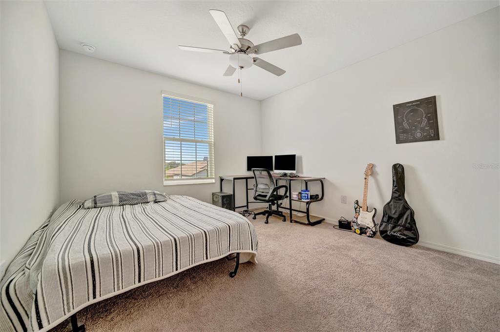 11112 Linden Depot Road San Antonio, FL 33576 - Photo 58 of 82 a bedroom with a bed a chair and a chandelier