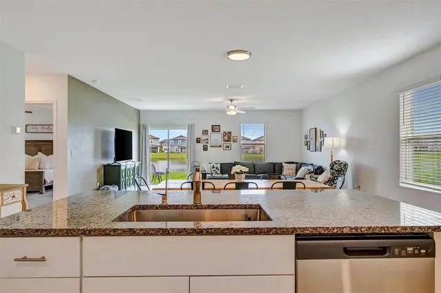 a kitchen with granite countertop a sink and cabinets