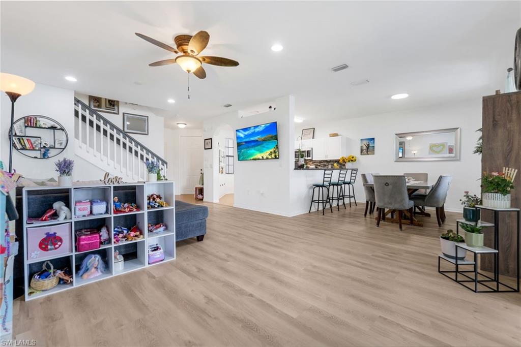 15239 Summit Pl Circle, Unit 246 Naples, FL 34119 - Photo 12 of 49 Living area featuring light wood-style flooring, a ceiling fan, recessed lighting, stairway, and a barn door