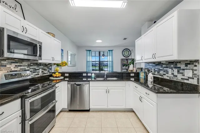 a kitchen with stainless steel appliances granite countertop a stove sink microwave and cabinets
