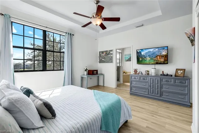 a bedroom with a large bed a chandelier and a window