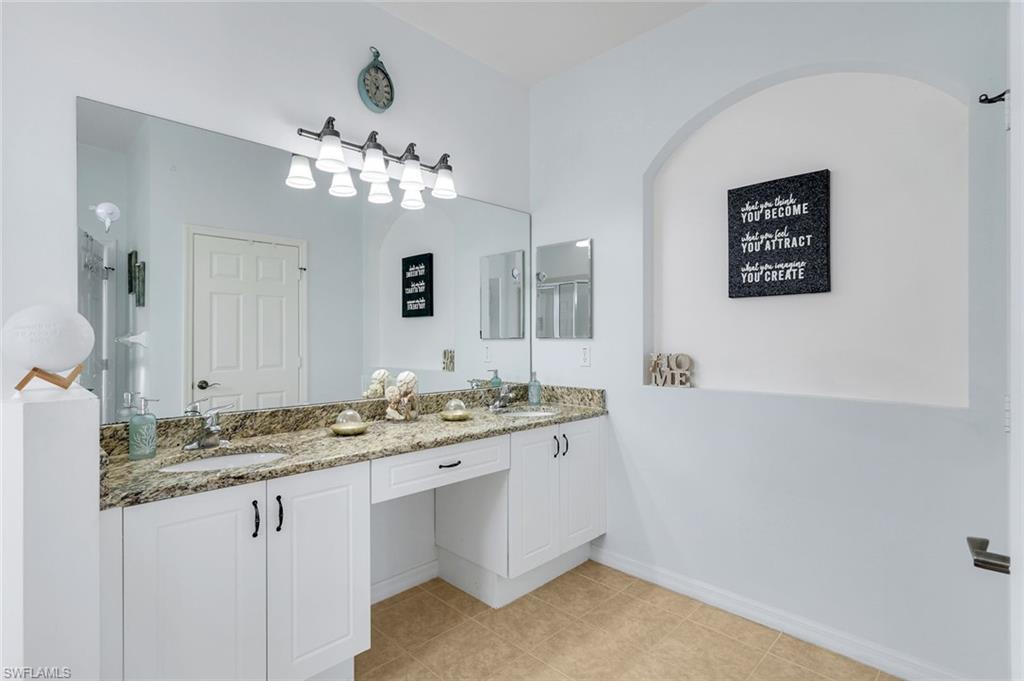 15239 Summit Pl Circle, Unit 246 Naples, FL 34119 - Photo 24 of 49 Full bath with double vanity and light tile patterned flooring