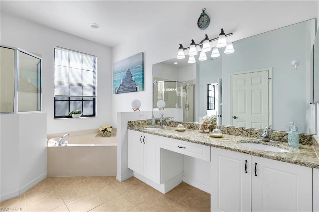 15239 Summit Pl Circle, Unit 246 Naples, FL 34119 - Photo 25 of 49 Full bathroom featuring a shower stall, a bath, double vanity, and light tile patterned floors