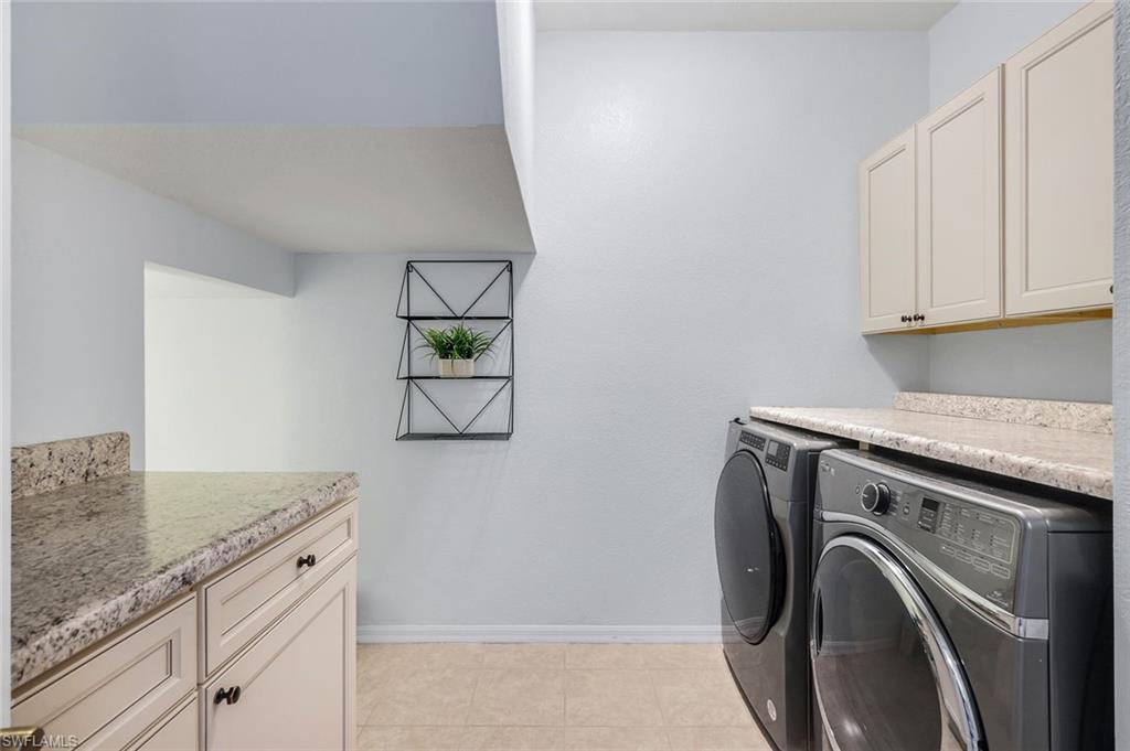 15239 Summit Pl Circle, Unit 246 Naples, FL 34119 - Photo 31 of 49 Washroom with cabinet space, independent washer and dryer, and light tile patterned floors