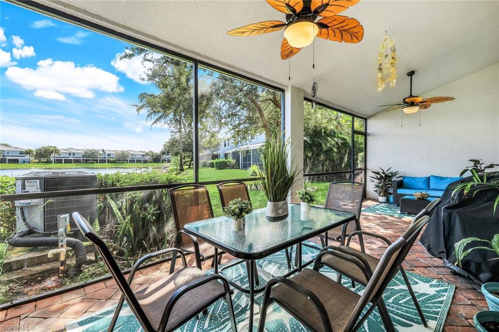 15239 Summit Pl Circle, Unit 246 Naples, FL 34119 - Photo 34 of 49 Sunroom with vaulted ceiling, expansive windows, and a water view