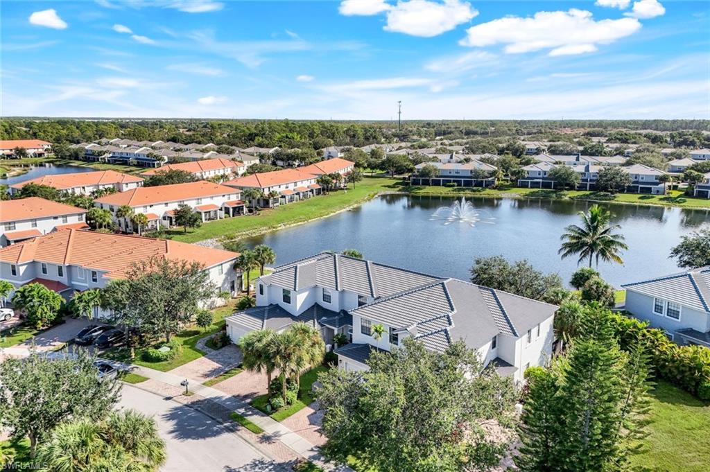15239 Summit Pl Circle, Unit 246 Naples, FL 34119 - Photo 39 of 49 Aerial perspective of suburban area with a nearby body of water and a tree filled landscape