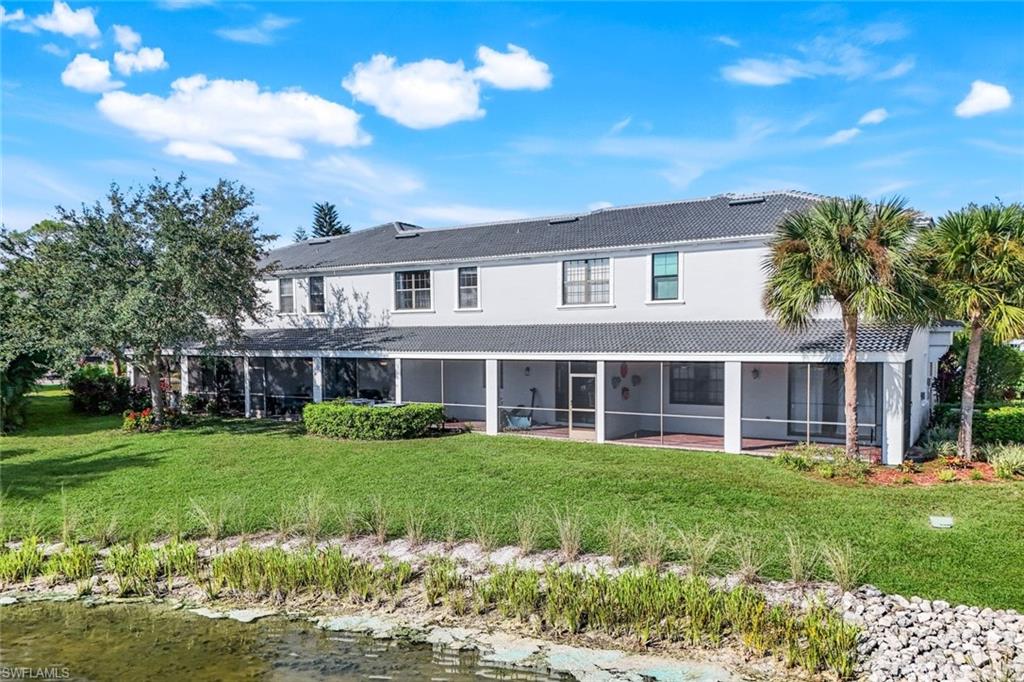 15239 Summit Pl Circle, Unit 246 Naples, FL 34119 - Photo 4 of 49 Back of house with a yard, a water view, a sunroom, and a tiled roof