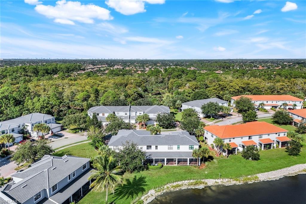 15239 Summit Pl Circle, Unit 246 Naples, FL 34119 - Photo 40 of 49 Aerial perspective of suburban area featuring a large body of water