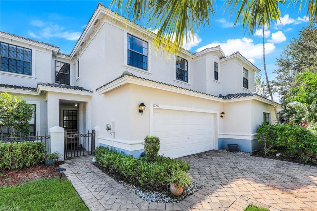 15239 Summit Pl Circle, Unit 246 Naples, FL 34119 - Photo 5 of 49 Mediterranean / spanish house with a garage, stucco siding, decorative driveway, and a tile roof